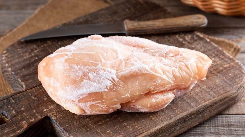 Frozen chicken on cutting board