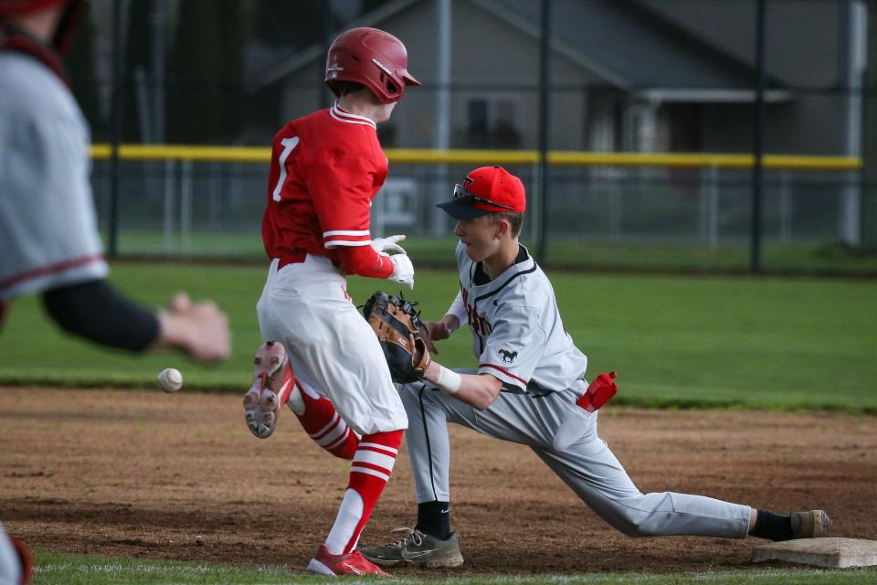 Thurston’s Grady Saunders makes a catch as North Eugene’s Brock Johnson is out at first as the Thurston Colts defeated the North Eugene Highlanders 9-0 Wednesday, April 12, 2023 at North Eugene High School.