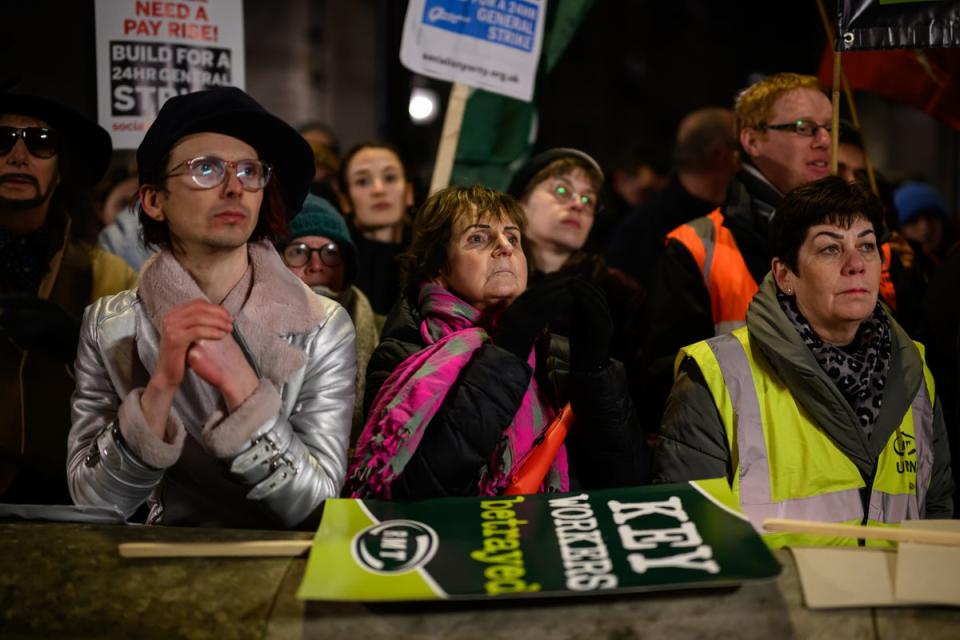 People hold placards and banners as they listen to speeches (Getty Images)