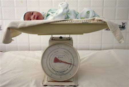 A newborn baby lies on a scale at a hospital in Suining, southwest China's Sichuan province in this September 14, 2007 file photo. REUTERS/Stringer/Files