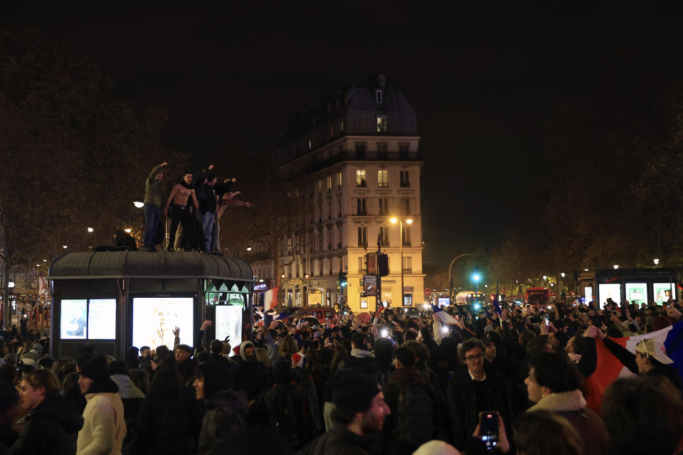 Supporters of France react in Bastille square at the end of the 2-0 victory of the World Cup semifinal soccer match between France and Morocco, in Paris, Wednesday, Dec. 14, 2022. (AP Photo/Aurelien Morissard)