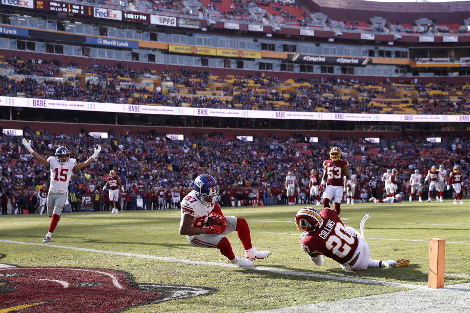 New York Giants wide receiver Sterling Shepard (87) falls into the end zone for a touchdown after making a catch on a pass from quarterback Daniel Jones, not visible, as Washington Redskins strong safety Landon Collins (20) tries to defend during the first half of an NFL football game, Sunday, Dec. 22, 2019, in Landover, Md. Giants' Golden Tate (15) reacts on the play. (AP Photo/Alex Brandon)