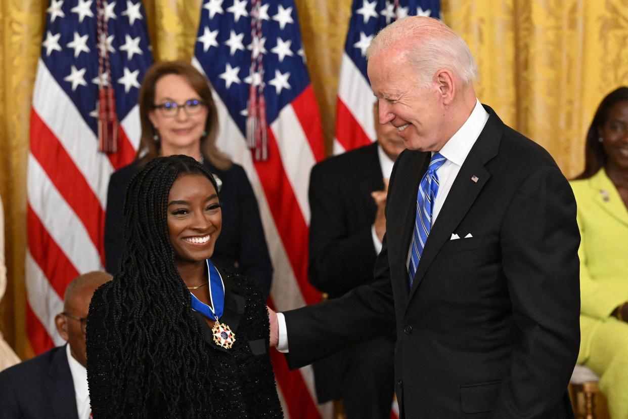 U.S. President Joe Biden presents gymnast Simone Biles with the Presidential Medal of Freedom, the nation's highest civilian honor, during a ceremony honoring 17 recipients in the East Room of the White House in Washington, DC on July 7, 2022.