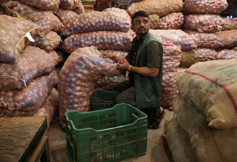 A man sorts onions at a vegetable wholesale market in Mumbai