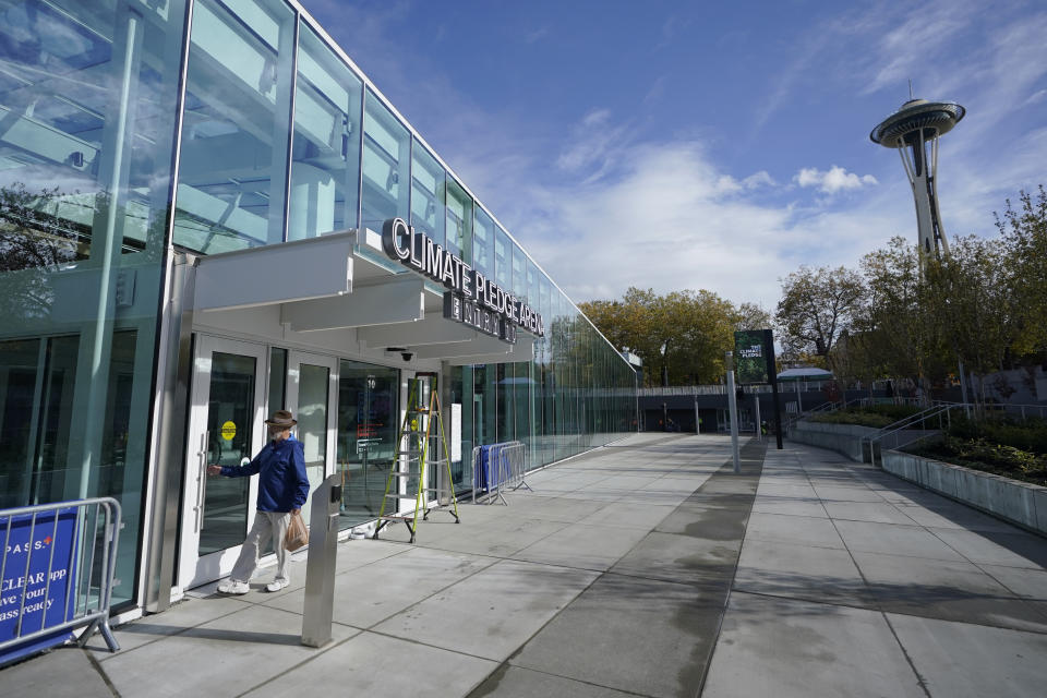 The glass atrium entrance to Climate Pledge Arena is shown Wednesday, Oct. 20, 2021, ahead of the NHL hockey Seattle Kraken's home opener Saturday against the Vancouver Canucks in Seattle. The historic angled roof of the former KeyArena was preserved, but everything else inside the venue, which will also host concerts and be the home of the WNBA Seattle Storm basketball team, is brand new. (AP Photo/Ted S. Warren)