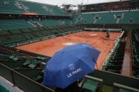 Tennis - French Open - Roland Garros- Paris, France - 30/05/16. A spectator uses an umbrella at the central court as rain falls in Paris. REUTERS/Pascal Rossignol