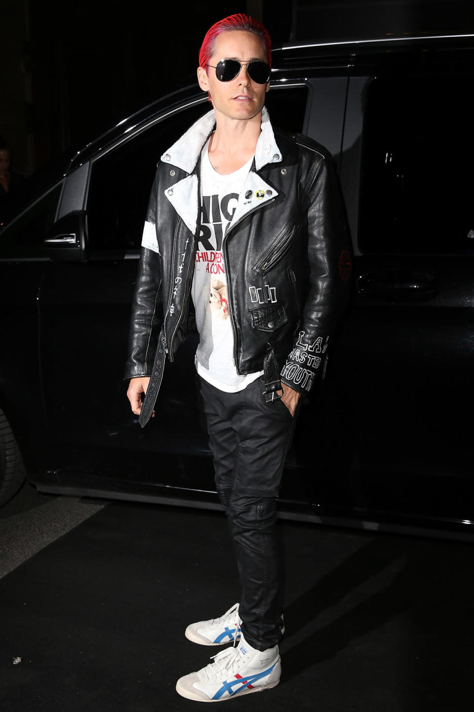 Jared Leto with pink hair, sunglasses and a black leather bomber jacket at the Vogue Paris 95th anniversary party.