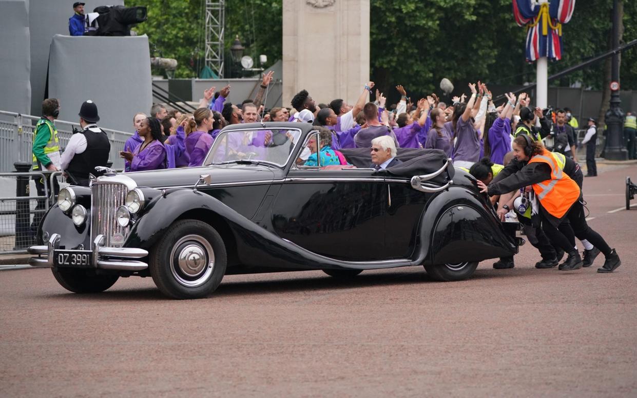 Volunteers push Prue Leith's car after it breaks down during the Platinum Pageant - Jonathan Brady/PA