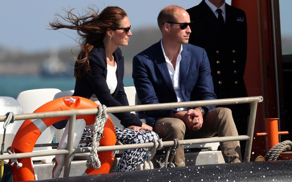 William and Kate sitting on a boat wearing dark glasses