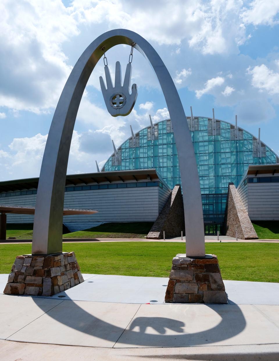 The sculpture "Touch to Above" by Cherokee artists Demos Glass and Bill Glass Jr., greets visitors at the First Americans Museum in Oklahoma City. The open hand is the universal welcome greeting for Native Americans and the cross represents the four directions, meaning all are welcome.