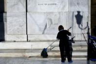 A worker cleans the steps of the National Bank of Greece in Athens