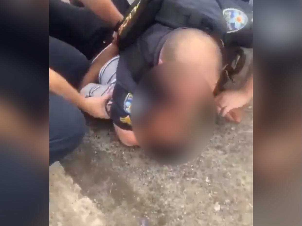 <p>In footage that was widely shared following the incident, an officer can be seen restraining a boy on the ground before sitting him up and putting his hands behind his back</p> (Twitter)