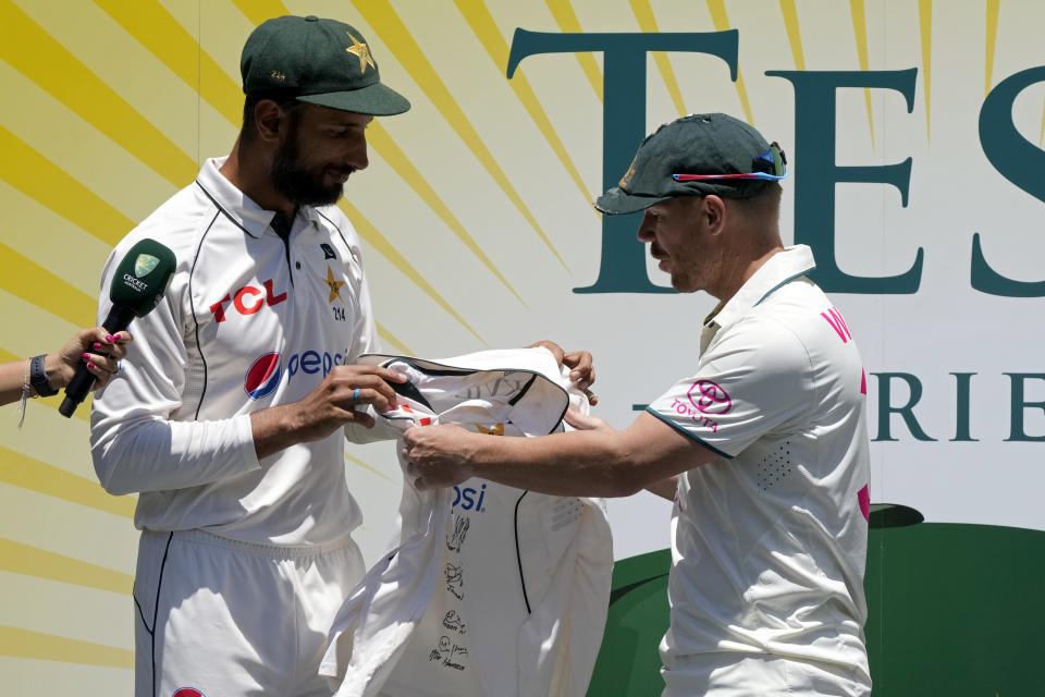 Pakistan's captain Shan Masood presents Australia's David Warner a shirt signed by the Pakistan players after Australia won on the fourth day of their cricket test against Pakistan match in Sydney, Saturday, Jan. 6, 2024. Australia also won the series 3-0. (AP Photo/Rick Rycroft)