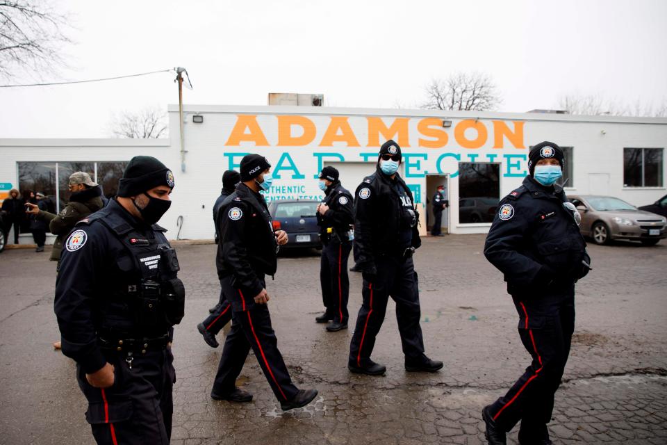 <p>Police gather in the car park of Adamson Barbecue</p> (AFP via Getty Images)