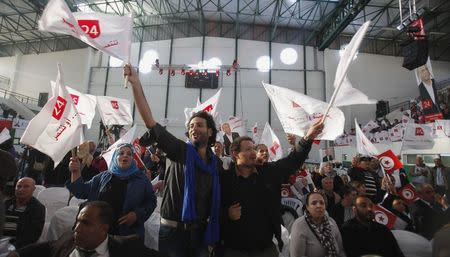 Supporters of Tunisia's President Moncef Marzouki, who is seeking re-election, wave banners and national flags during a presidential electoral campaign rally in Tunis November 21, 2014. REUTERS/Zoubeir Souissi