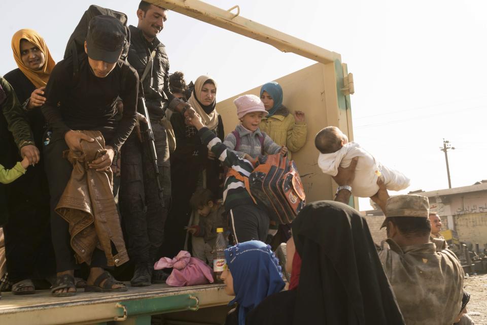 Iraqi soldiers help women and children who have fled fighting in Mosul into trucks to take them to camps in this Saturday, Nov. 12, 2016 photo taken at a checkpoint in Mosul’s Gogjali district, Iraq. Under IS rule in Mosul, many families kept their children out of the schools, which were run by the militants and used to instill their radical ideology. They even purged plus signs from math books because they looked like Christian crosses, residents say. (AP Photo/Nish Nalbandian)