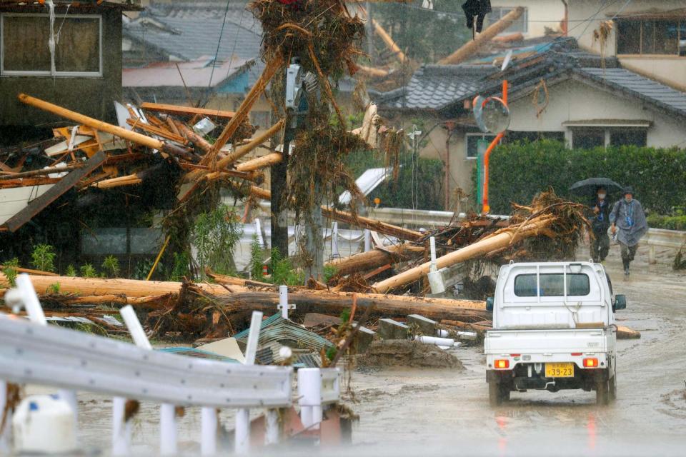 Debris lines the streets in Kumamura (AP)