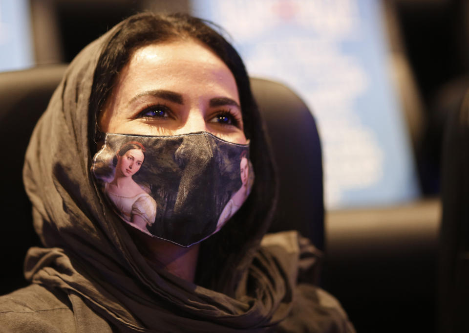 In this June 26, 2020 photo, a Saudi woman wears a colored face mask to help curb the spread of the coronavirus, at VOX Cinema hall in Jiddah, Saudi Arabia. In the two decades since Sept. 11, 2001, Saudi Arabia has confronted al-Qaida on its own soil, revamped its textbooks, worked to curb terror financing and partnered with the United States to counter terrorism. (AP Photo/Amr Nabil)