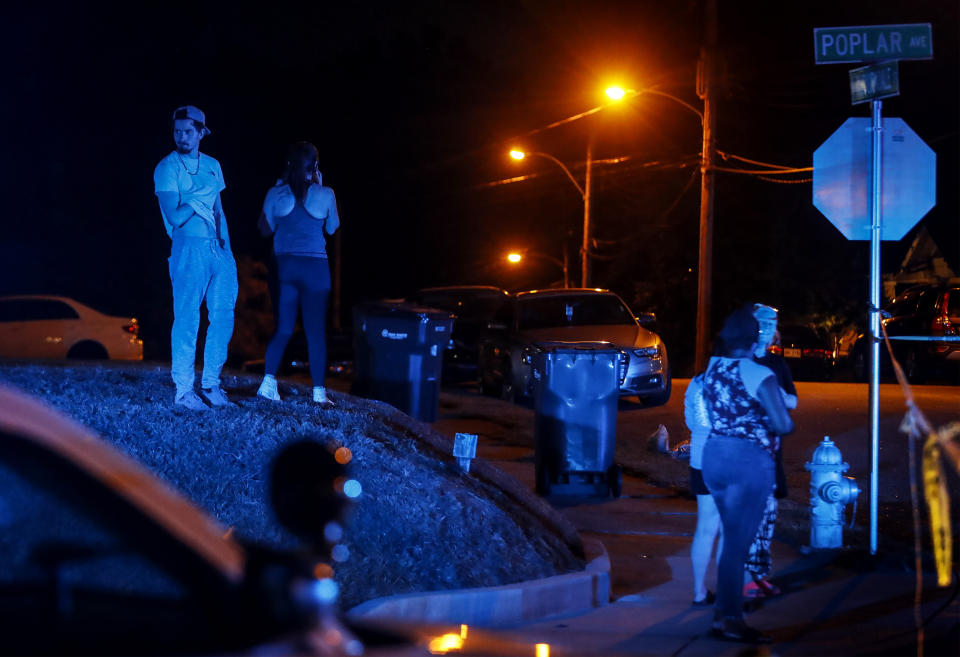 Onlookers watch Memphis Police officers work an active shooter scene on Poplar Avenue in Memphis, Tenn. Wednesday, Sept. 7, 2022. Police in Memphis, Tennessee, said a man who drove around the city shooting at people during an hours-long rampage that forced frightened people to shelter in place Wednesday has been arrested. (Mark Weber/Daily Memphian via AP)