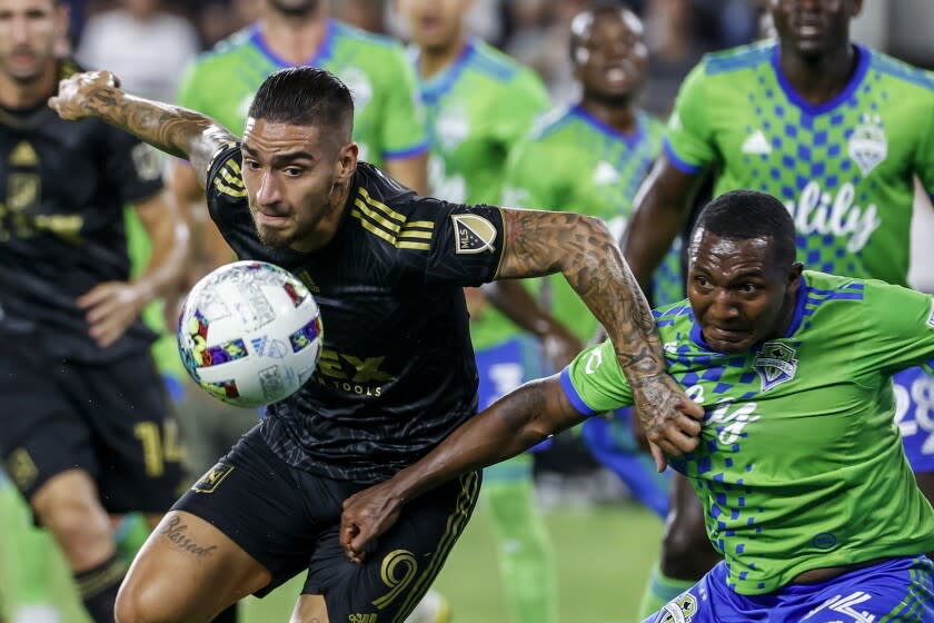 Los Angeles FC forward Cristian Arango, left, and Seattle Sounders defender Jimmy Medranda vie for the ball during the first half of an MLS soccer match Friday, July 29, 2022, in Los Angeles. (AP Photo/Ringo H.W. Chiu)