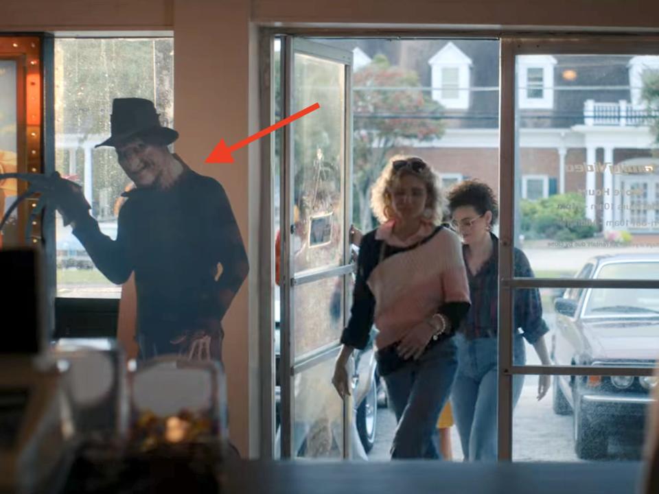 A scene from Netflix's sci-fi series "Stranger Things," showing two teens entering a video store.