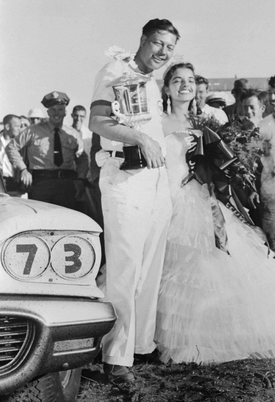 race car driver johnny beauchamp with trophy and speed week queen