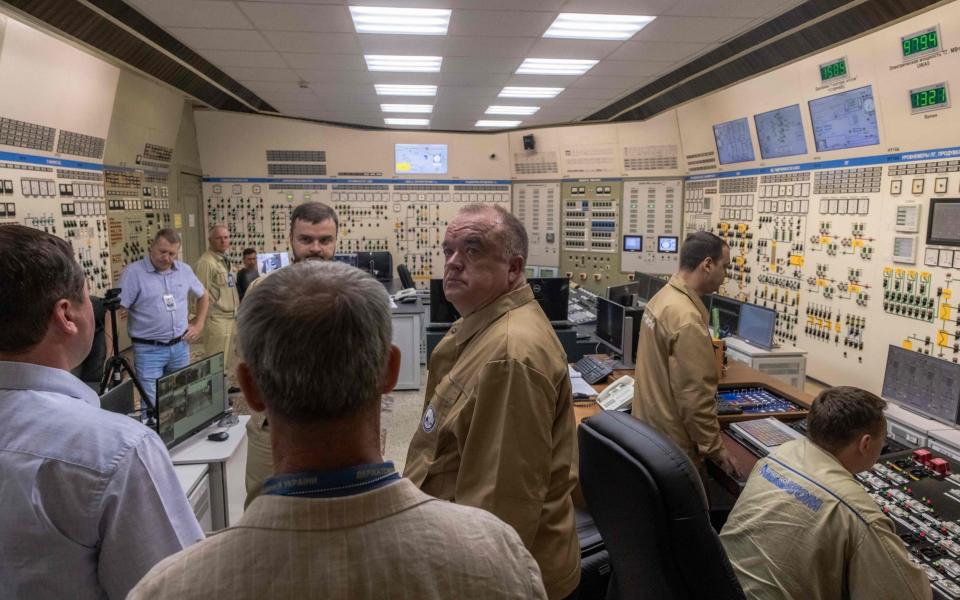 President of Ukraine's state nuclear energy agency Energoatom, Petro Kotin (C), stands with employees as he visits the control room of the South Ukraine Nuclear Power Plant near the city of Yuzhnoukrainsk in Mykolaiv region on August 7, 2023