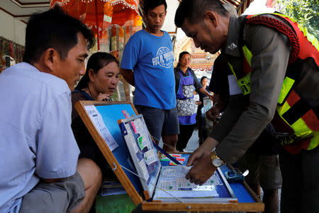 People buy lottery tickets outside the Wat Kunnatri Ruttharam temple in Bangkok, Thailand November 1, 2018. Picture taken November 1, 2018. REUTERS/Jorge Silva