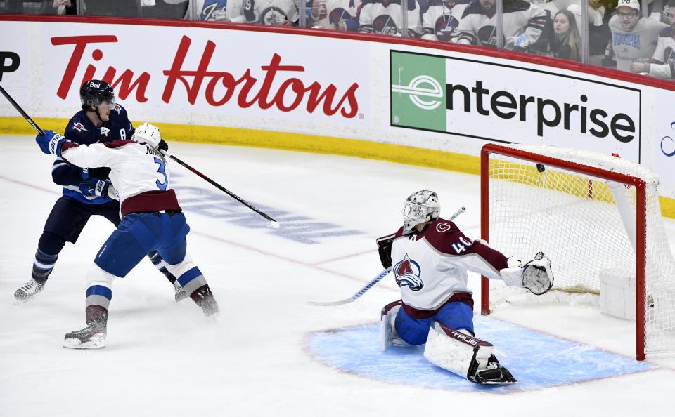 Winnipeg Jets' Mark Scheifele (55) scores on Colorado Avalanche goaltender Alexandar Georgiev (40) as Colorado's Jack Johnson (3) defends during the second period in Game 2 of an NHL hockey Stanley Cup first-round playoff series Tuesday, April 23, 2024, in Winnipeg, Manitoba. (Fred Greenslade/The Canadian Press via AP)