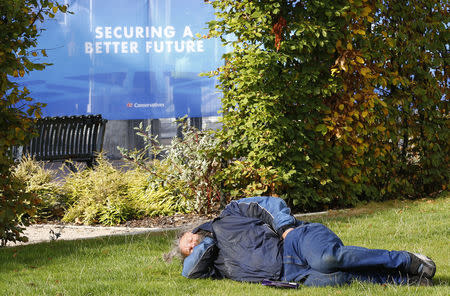A man sleeps on the grass outside the Conservative Party Conference in Birmingham, central England September 30, 2014. REUTERS/Darren Staples