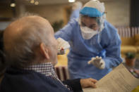In this photo taken on Wednesday April 1, 2020, aid workers from the Spanish NGO Open Arms carry out coronavirus detection tests on the elderly at a nursing home in Barcelona, Spain. The initiative is part of a clinical trial led by doctors Oriol Mitja and Bonaventura Clotet, from the Lluita Foundation against AIDS and the Germans Trias Hospital, focused on cutting down virus transmission. Spain has seen Thursday a new record in virus-related fatalities that came as the country is seeing the growth of contagion waning, health ministry data showed placing Spain neck to neck with Italy, the country that saw the worst outbreak in Europe. The COVID-19 coronavirus causes mild or moderate symptoms for most people, but for some, especially older adults and people with existing health problems, it can cause more severe illness or death.(AP Photo/Santi Palacios)