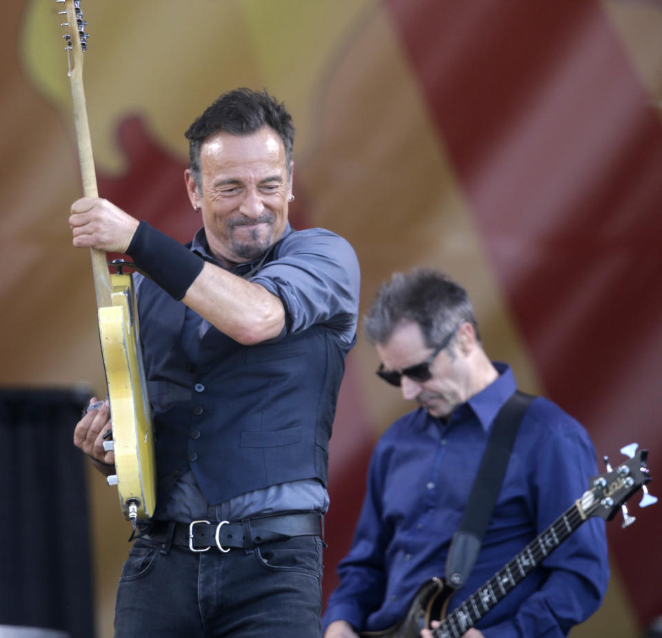 Bruce Springsteen performs with bassist Garry Tallent, background, at the New Orleans Jazz and Heritage Festival in New Orleans, Saturday, May 3, 2014. (AP Photo/Gerald Herbert)