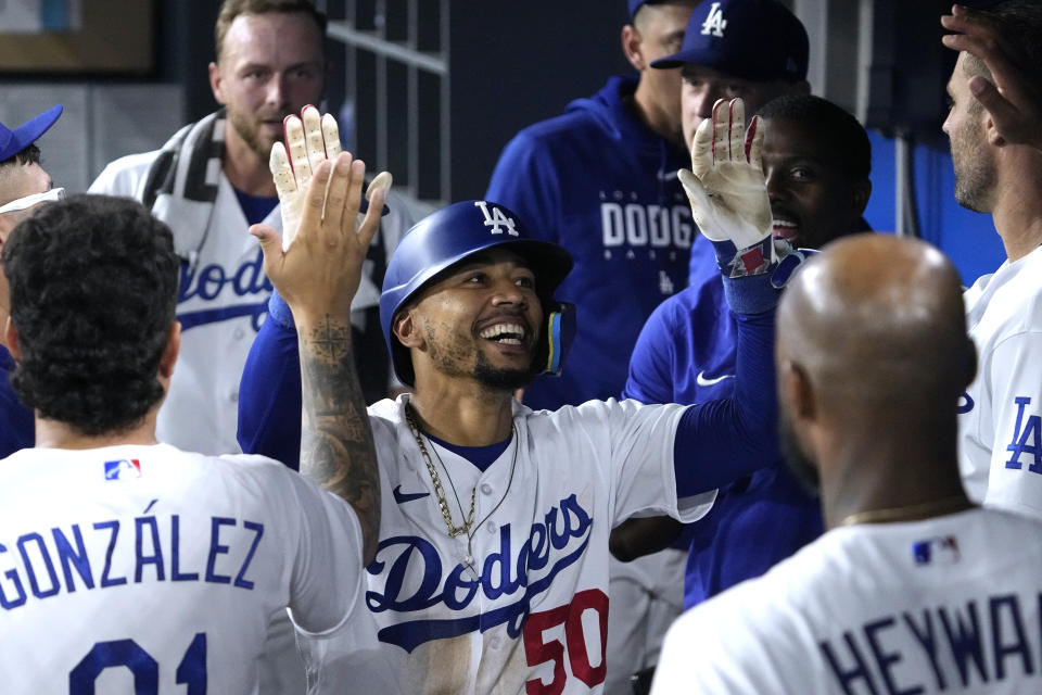 Los Angeles Dodgers' Mookie Betts is congratulated by teammates in the dugout after hitting a solo home run during the seventh inning of a baseball game against the Atlanta Braves Thursday, Aug. 31, 2023, in Los Angeles. (AP Photo/Mark J. Terrill)