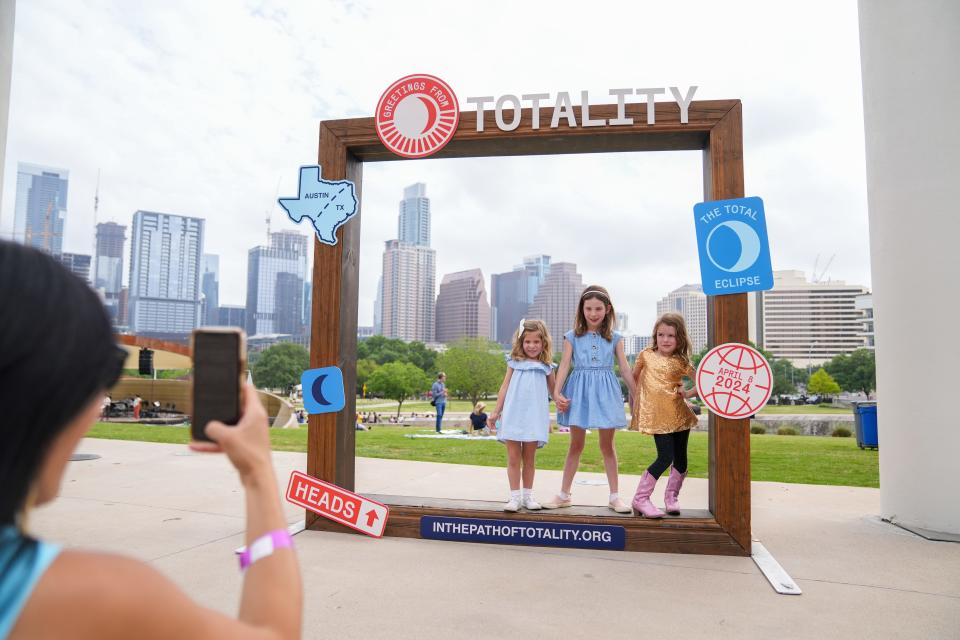 Emma Amos, Libby Amos and Lydia Witherspoon pose as Libby and Emma's mom snaps a picture during the Long Center's total solar eclipse viewing party on April 8.