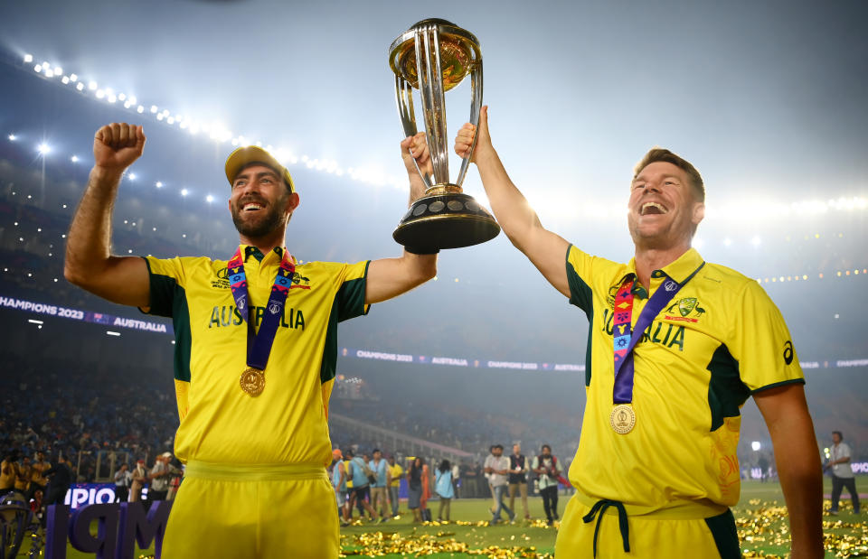 AHMEDABAD, INDIA - NOVEMBER 19: Glenn Maxwell and David Warner of Australia poses with the ICC Men's Cricket World Cup Trophy following the ICC Men's Cricket World Cup India 2023 Final between India and Australia at Narendra Modi Stadium on November 19, 2023 in Ahmedabad, India. (Photo by Alex Davidson-ICC/ICC via Getty Images)