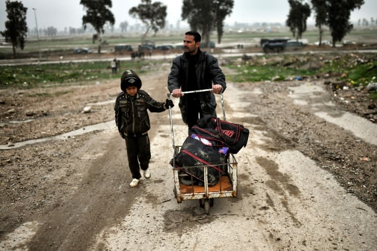 Samir Hamid and his 12-year-old son, who were displaced from Mosul due to the ongoing fighting between Iraqi forces and Islamic State (IS) group jihadists, return to the city on March 17, 2017