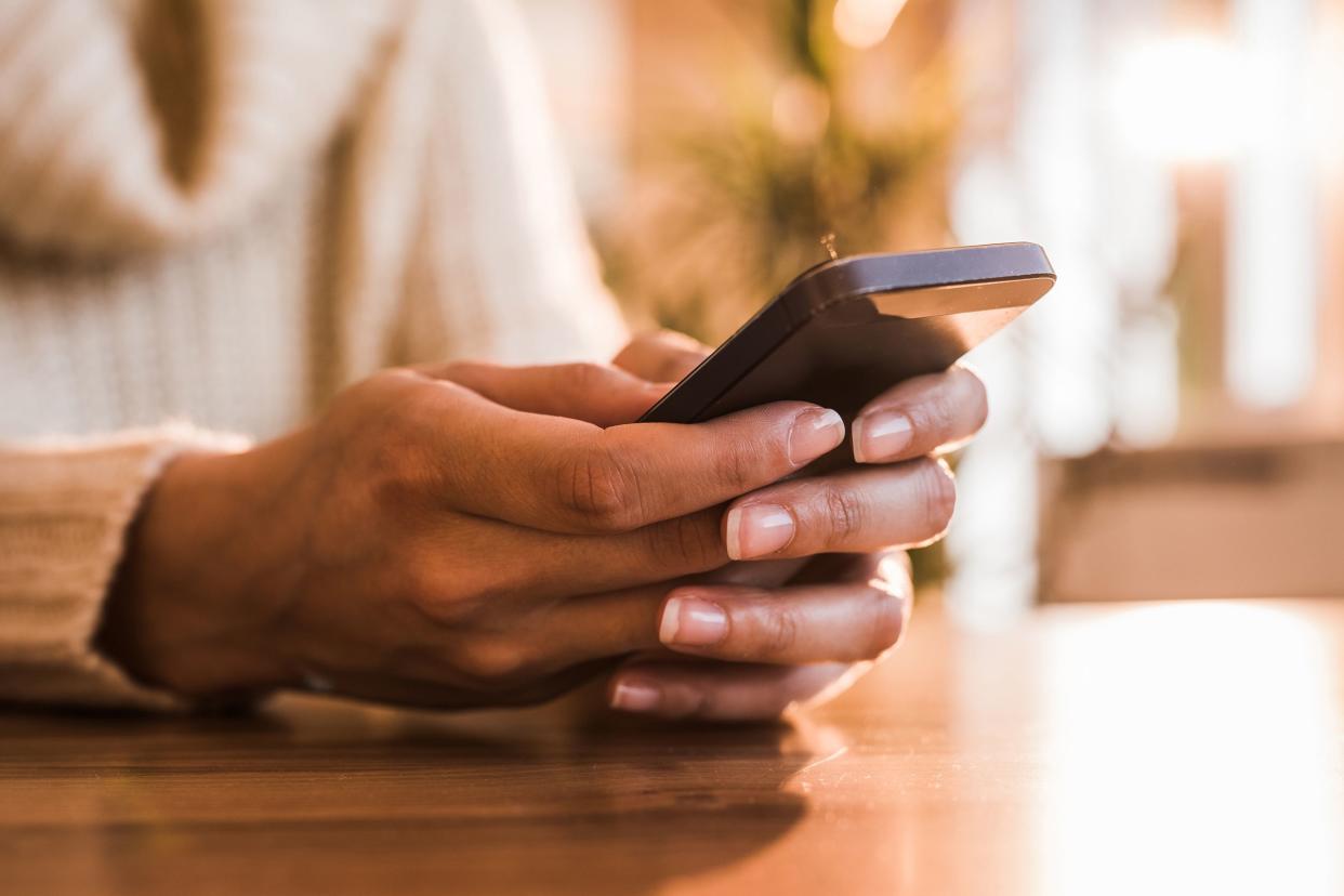 middle-aged senior woman's hands holding cell phone