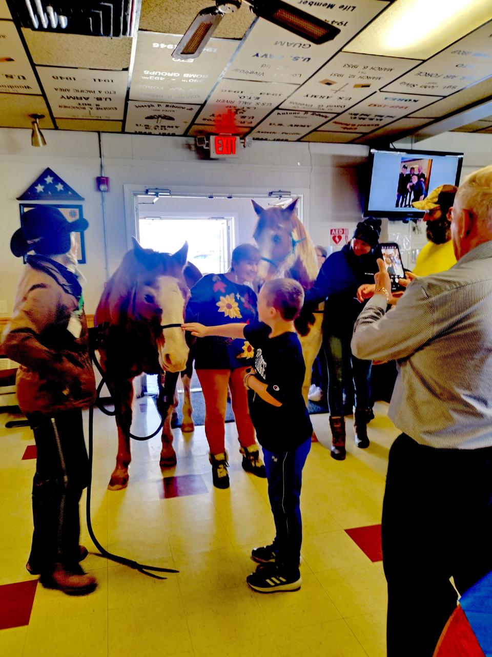 Carol Silva, left, of Medicine Horse, keeps an eye on her four-legged therapists during a President’s Day visit to the Tiverton VFW hall.