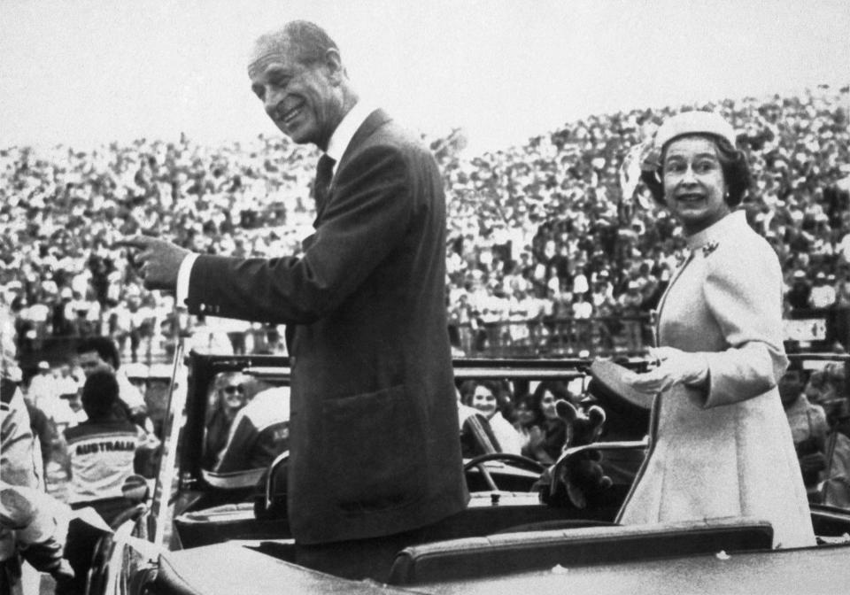 FILE - In this Oct. 9, 1982 file photo, Britain's Queen Elizabeth and Prince Philip looks back as they drive through the crowd of athletes and officials during the closing ceremony of the 12th Commonwealth Games, in the Queen Elizabeth II Jubilee Sports Centre, Brisbane, Australia. Buckingham Palace officials say Prince Philip, the husband of Queen Elizabeth II, has died, it was announced on Friday, April 9, 2021. He was 99. Philip spent a month in hospital earlier this year before being released on March 16 to return to Windsor Castle. Philip, also known as the Duke of Edinburgh, married Elizabeth in 1947 and was the longest-serving consort in British history. (AP Photo/Pool, File)