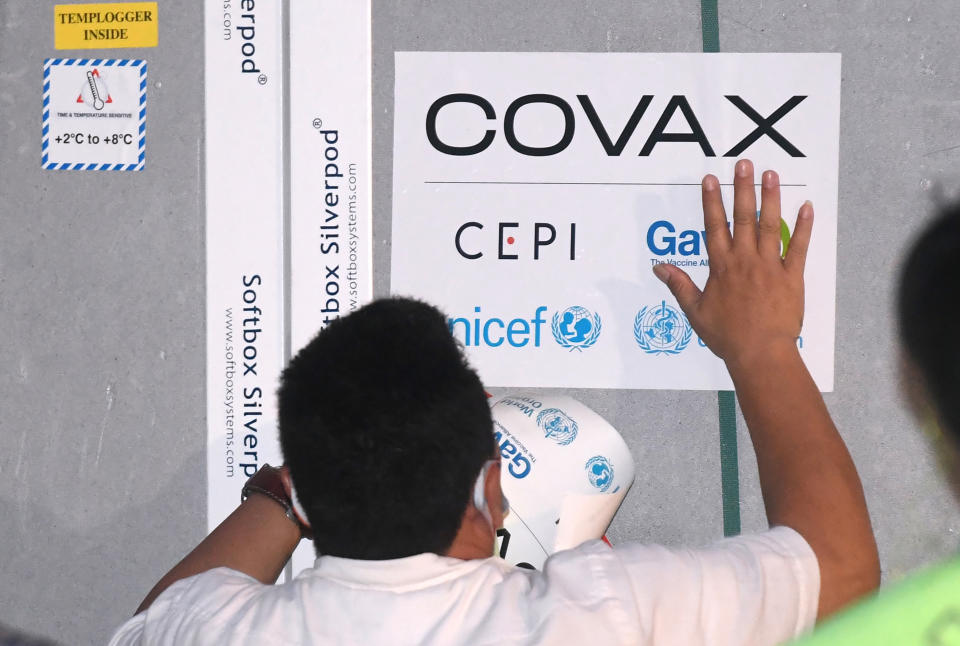 In this photo released by Indonesian Presidential Palace, a worker attaches a sticker on a container containing AstraZeneca COVID-19 vaccine upon its arrival at Soekarno-Hatta International Airport in Tangerang on the outskirts of Jakarta, Indonesia March 8, 2021 . Indonesia on Friday, March 19, 2021 cleared the AstraZeneca vaccine for use again after the European Union's drug regulator said the vaccine didn't increase the overall incidence of blood clots. (Indonesian President Palace via AP)