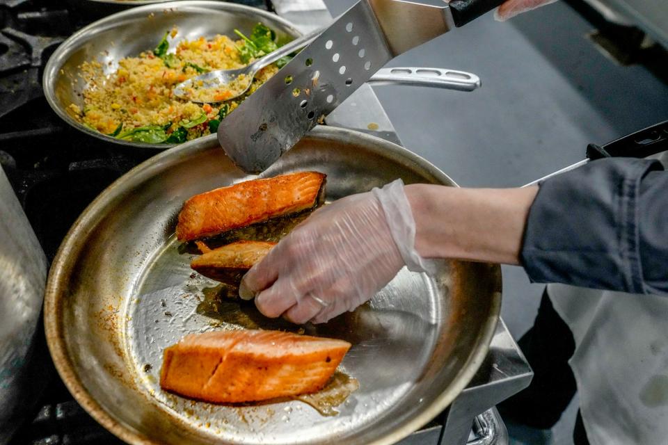 Chef Stephanie Duquette at PACE Rhode Island prepares a meal of pan-seared salmon with spring herb pesto, roasted quinoa and herb roasted sunchokes.