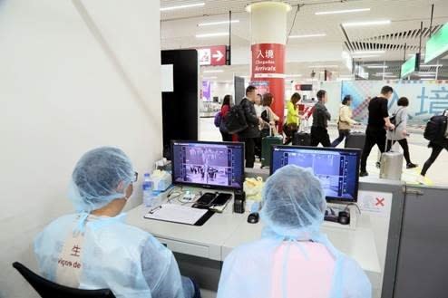 Officials monitor thermal scanners at a temperature monitoring station at Macau International Airport in Macau