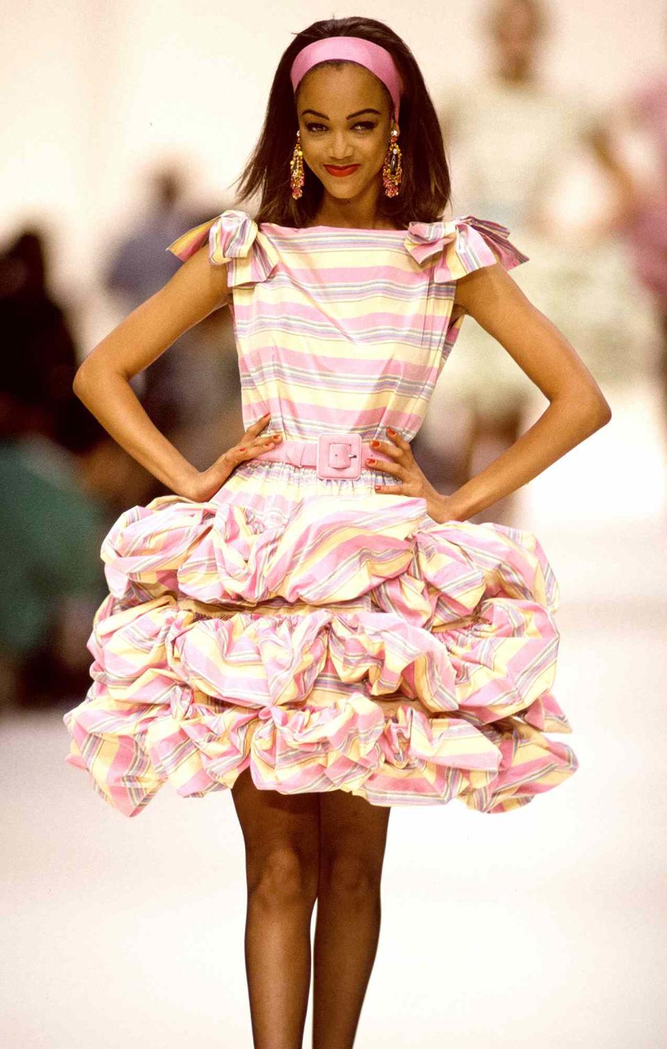 <p>Tyra Banks burst onto the scene in 1991 when she first walked in Paris Fashion Week. Here, she struts her stuff at the Yves Saint Laurent show in October of that year.</p>