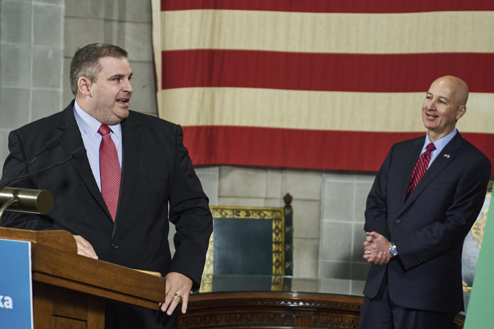 Department of Health and Human Services Interim Director of Medicaid & Long-Term Care, Jeremy Brunssen, left, turns to Neb. Gov. Pete Ricketts during a news conference in Lincoln, Neb., Wednesday, Sept. 30, 2020. Nebraska will officially offer expanded Medicaid coverage to low-income individuals starting Thursday after years of political battles in the Legislature, a statewide ballot campaign to force the issue and a nearly two-year rollout that left some residents in healthcare limbo. (AP Photo/Nati Harnik)