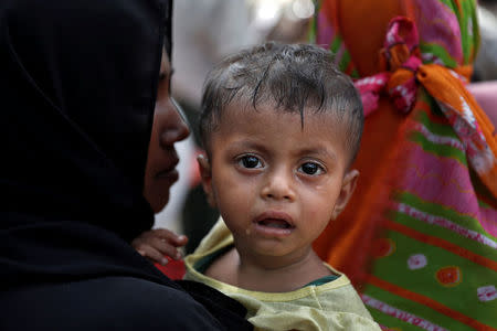 A Rohingya refugee child reacts as people wait to receive aid in Cox's Bazar, Bangladesh, September 23, 2017. REUTERS/Cathal McNaughton