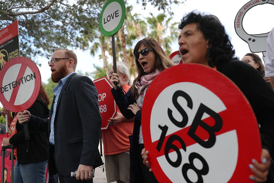 Yaquelin Lopez (right) and Margarita Mustelier stand with other activists across the street from a U.S. Immigration and Customs Enforcement (ICE) office in Miramar, Fla., on April 10, 2019, to protest "anti-sanctuary" bills moving through the Florida Legislature.