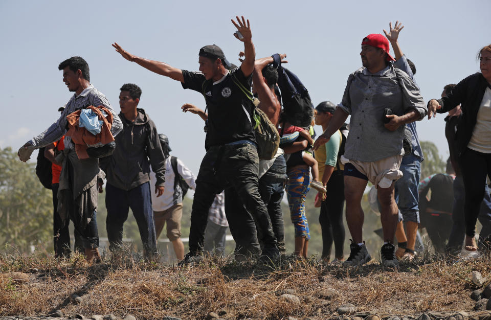 Central American migrants who crossed the Suchiate River from Guatemala to Mexico approach Mexican security forces on the bank of the river, near Ciudad Hidalgo, Mexico, Monday, Jan. 20, 2020. More than a thousand Central American migrants hoping to reach United States marooned in Guatemala are walking en masse across a river leading to Mexico in an attempt to convince authorities there to allow them passage through the country.(AP Photo/Marco Ugarte)