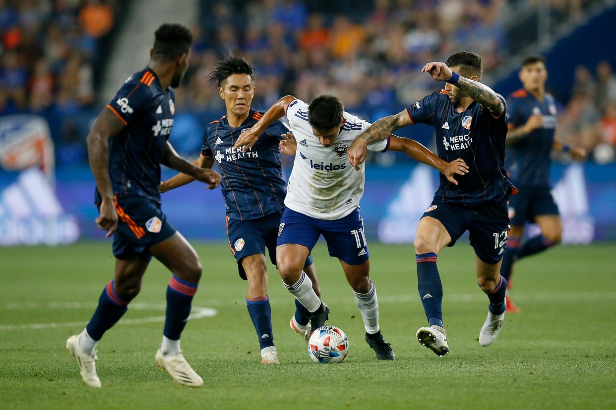 D.C. United midfielder Yamil Asad (11) is attacked by FC Cincinnati forward Yuya Kubo (7) and defender Geoff Cameron (12) in the second half of the MLS match between FC Cincinnati and D.C. United at TQL Stadium in the West End neighborhood of Cincinnati on Saturday, July 31, 2021. The match ended in a scoreless tie. 