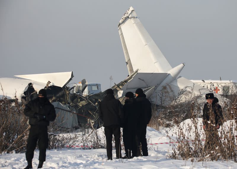 Emergency and security personnel are seen at the site of a plane crash near Almaty