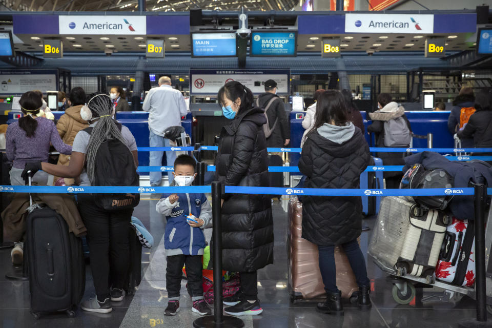 Travelers wearing face masks line up to check in for an American Airlines flight to Los Angeles at Beijing Capital International Airport in Beijing, Thursday, Jan. 30, 2020. China counted 170 deaths from a new virus Thursday and more countries reported infections, including some spread locally, as foreign evacuees from China's worst-hit region returned home to medical observation and even isolation. (AP Photo/Mark Schiefelbein)